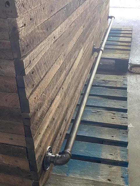 Full length shot of mounted galvanized foot rail on rustic bar, shown on pallet