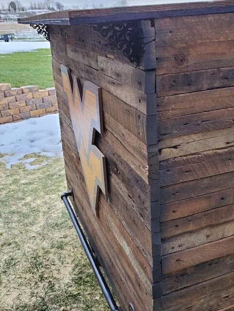 Close-up of black foot rail mounted to reclaimed wood bar with iron brackets