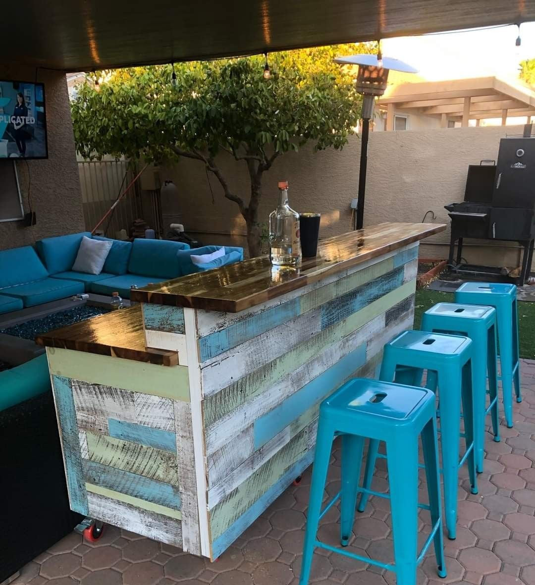 Coastal bar with reclaimed wood and glossy top in a tropical backyard setup by Red Cloak Wood Designs.