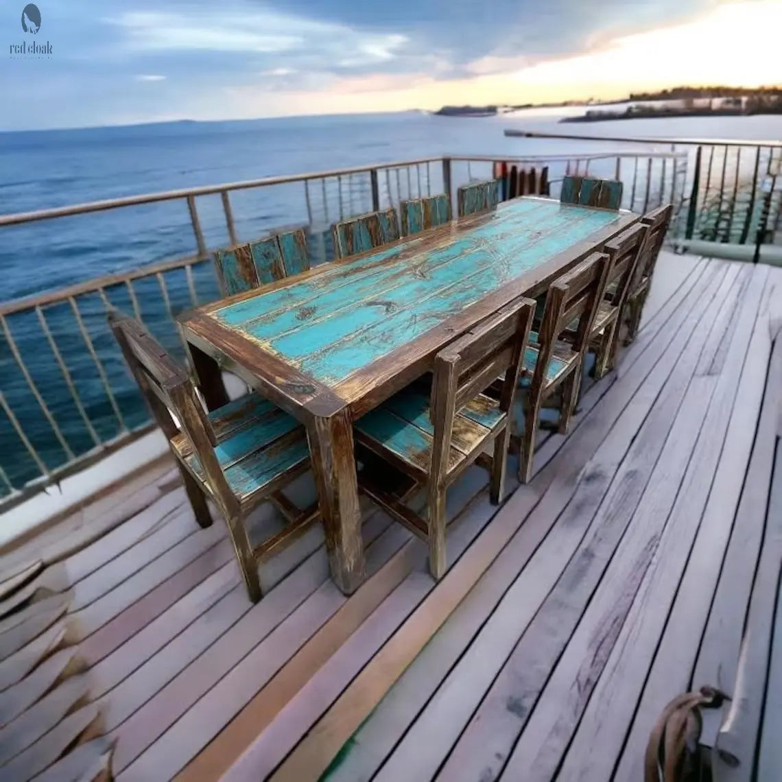Custom outdoor dining set on oceanview deck, featuring a teal-finished reclaimed wood table with eight matching chairs