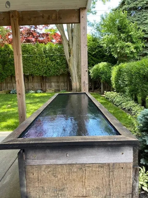 Reclaimed wood bar with fridge under covered patio and sealed black top