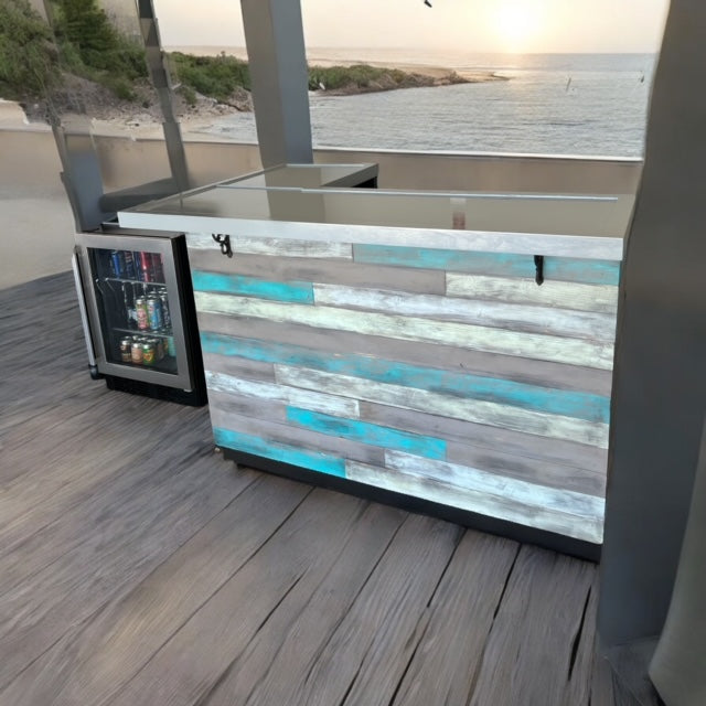 Reclaimed barnwood coastal bar with L shape design and glossy top, set on a deck with beach view by Red Cloak Wood Designs.
