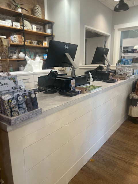 Close-up of white shiplap cash wrap counter with POS stations and retail impulse displays, handcrafted by Red Cloak Wood Designs