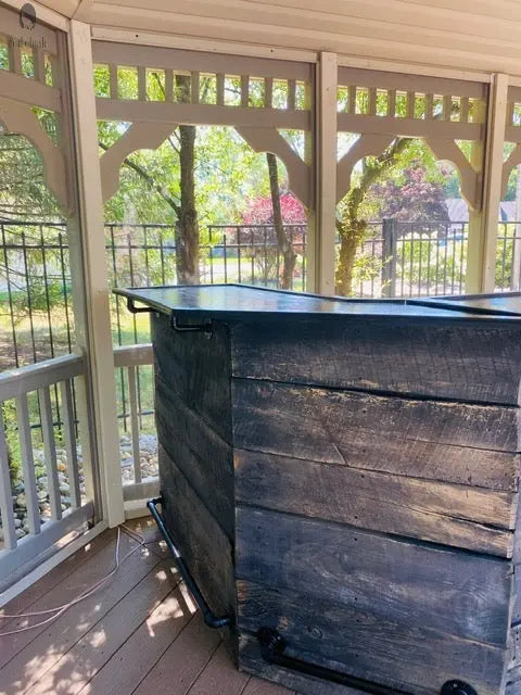 Endcap view of barnwood outdoor bar showing rustic texture and footrail, made for long-term backyard use