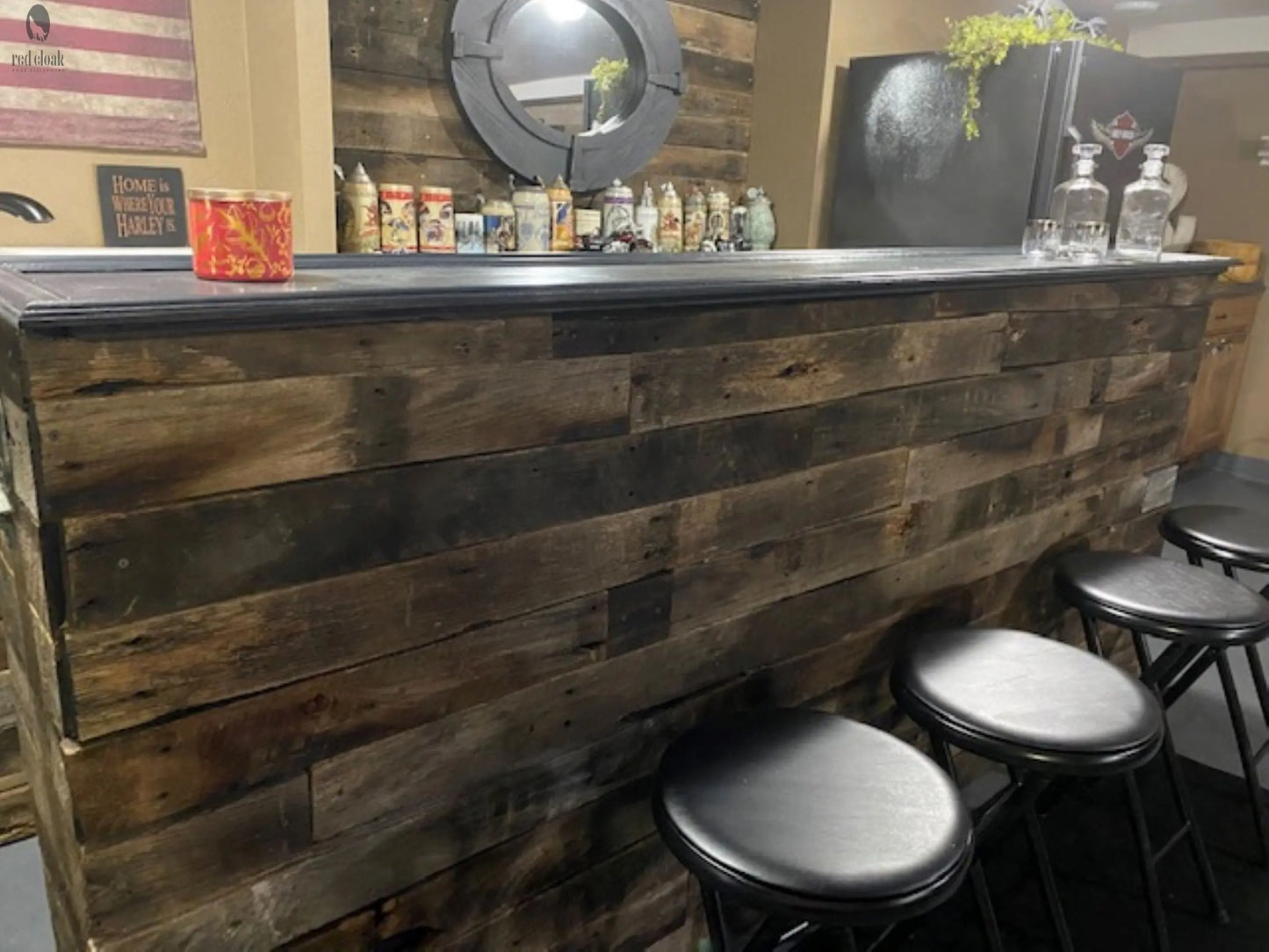 Custom wood bar with built-in fridge and black seating in indoor setup