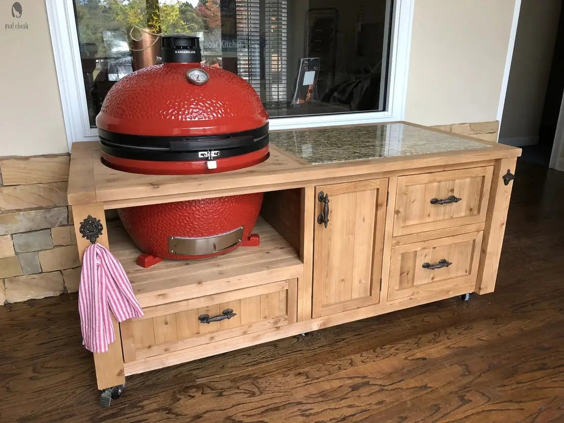 Kamado Joe grill in natural cedar smoker cart with granite prep area and drawer storage by Red Cloak Wood Designs.