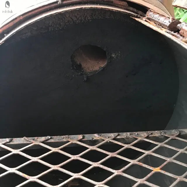 steel firebox inside longhorn BBQ grill showing burn mark and vent hole, handcrafted grilling unit. Handmade by Red Cloak Wood Designs