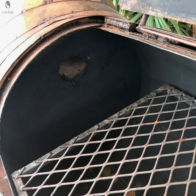 interior view of copper longhorn BBQ grill with steel chamber and cooking grate, Texas-style outdoor grill. Handmade by Red Cloak Wood Designs