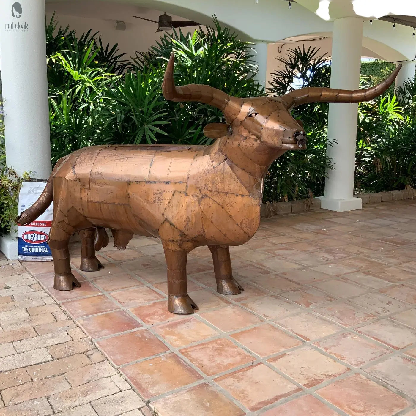 Right-side view of Long Horn Steer Grill on tiled patio with full horns and tail visible
