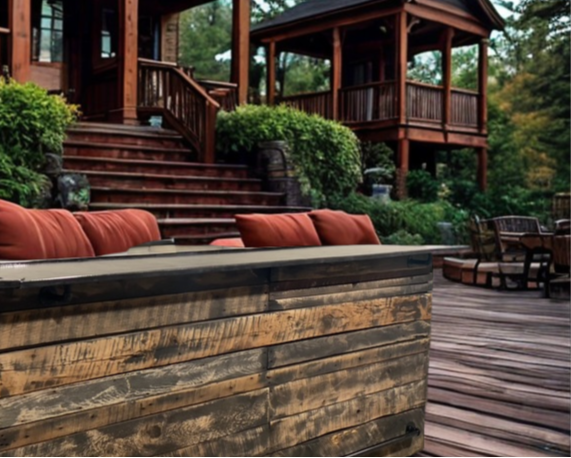 Rustic barnwood bar on a large cabin deck surrounded by forest, built by Red Cloak Wood Designs for outdoor entertaining