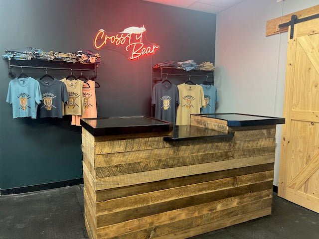 Angled view of rustic retail counter with reclaimed barnwood body and black POS shelf