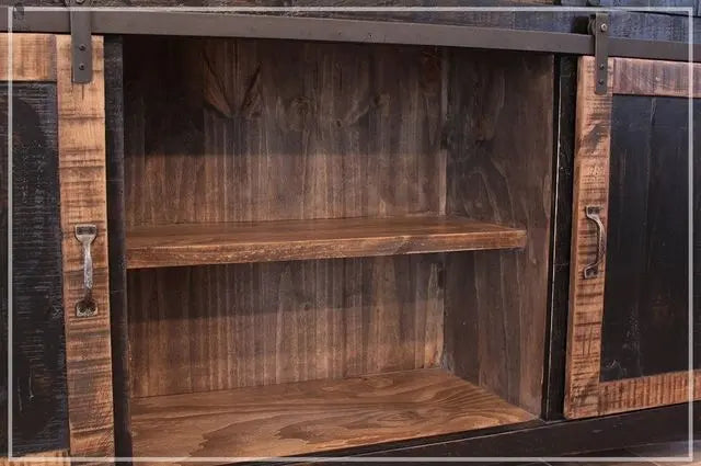 Interior shelving of rustic wood kitchen island with sliding barn door open and solid wood shelf visible