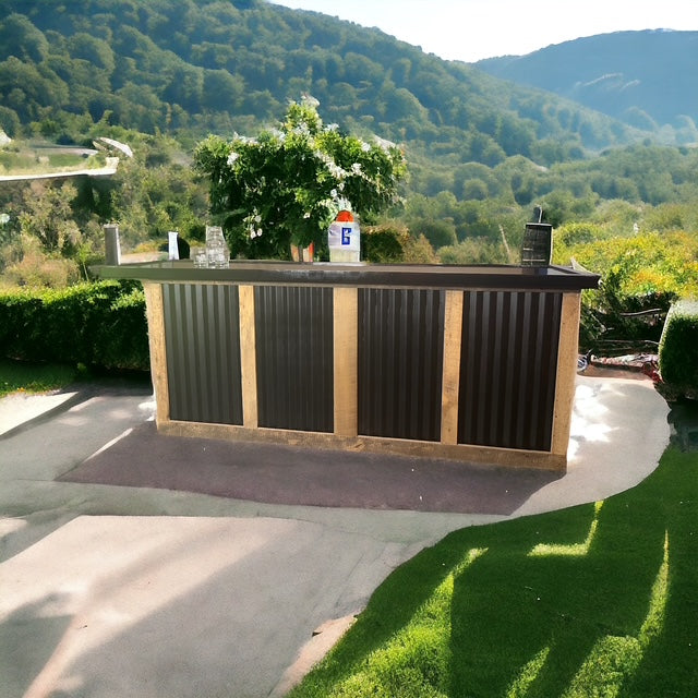 Red Cloak Home straight bar made of wood and black galvanized metal, styled outdoors with a mountain backdrop