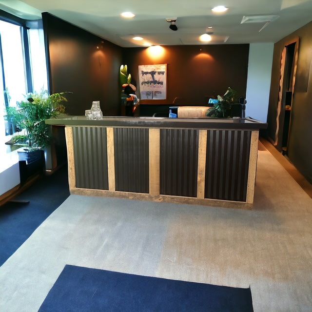 Indoor reclaimed wood and galvanized metal bar by Red Cloak Home, styled in a modern black-walled room