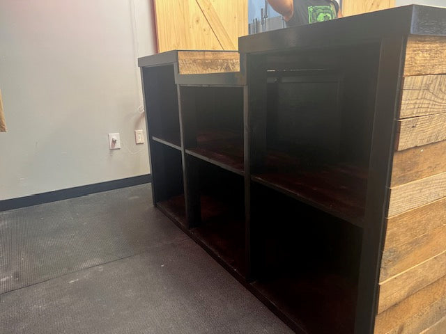 Backside view of reclaimed wood checkout counter showing deep storage shelves and sturdy frame