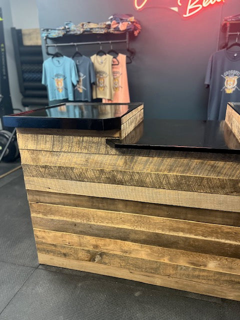 Corner view of rustic retail checkout counter with textured reclaimed wood and gloss top in Pennsylvania boutique