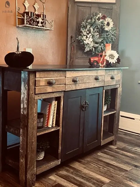 Side angle of rustic wood kitchen island with shelves and drawers, styled with books and plants. Made by Red Cloak Wood Designs