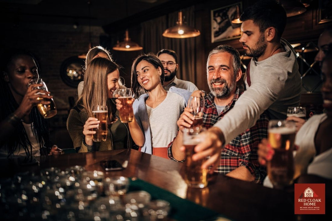Friends gathered around a reclaimed barnwood home bar by Red Cloak, enjoying drinks and conversation in a warm indoor entertaining space