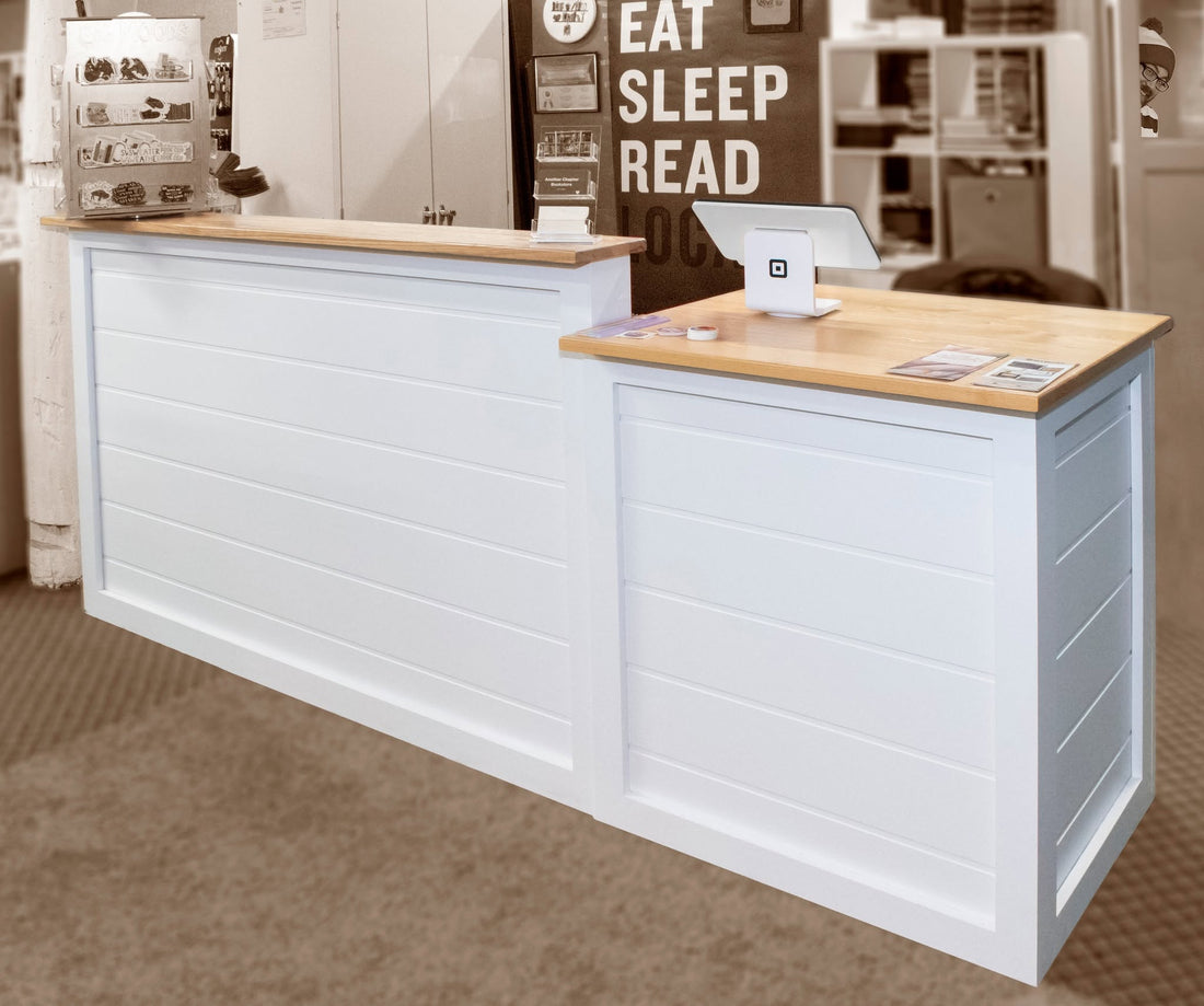 White retail checkout counter with wood top and POS station inside a bookstore custom made by Red Cloak Home