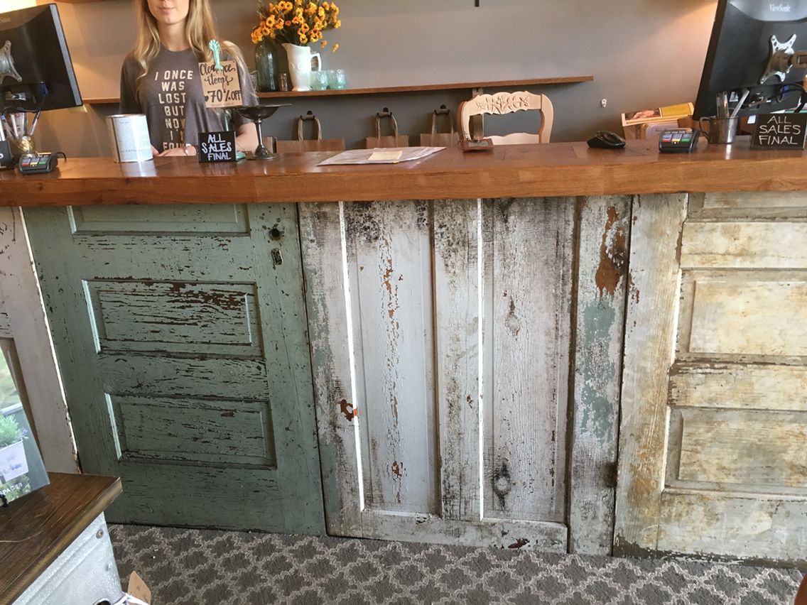 Long reclaimed door cash wrap counter with POS stations inside a boutique clothing store. Handmade by Red Cloak Home