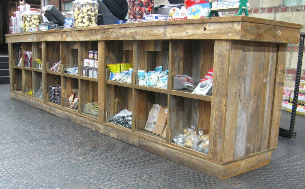 a rustic handmade barn wood retail counter / checkout counter with cubbys to display products to customers