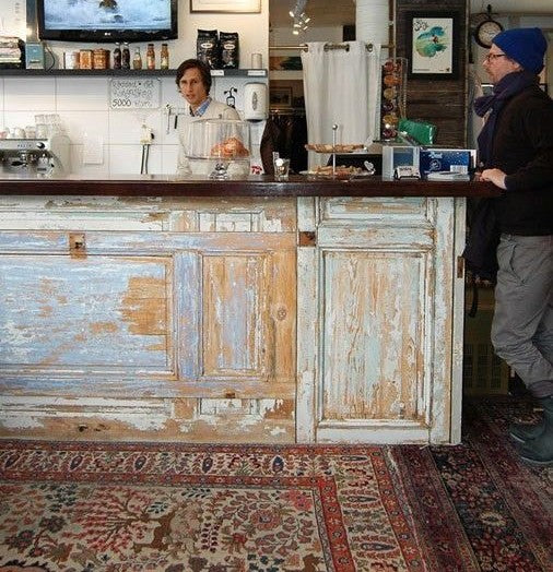 Vintage door checkout counter with distressed blue and white panels inside a café. Handmade by Red Cloak Home