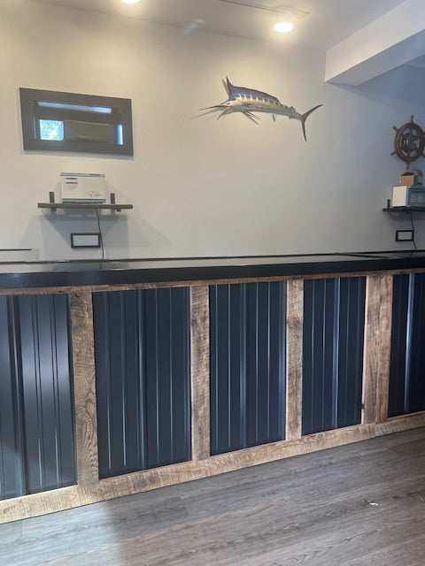 front view of L-shaped commercial counter with wood frame and black metal panels, custom retail checkout counter with sealed countertop in service space, USA