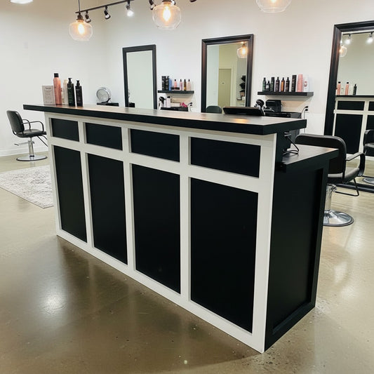 Black and white two-tier cash wrap counter with raised transaction ledge inside a modern hair salon. Handmade by Red Cloak Home