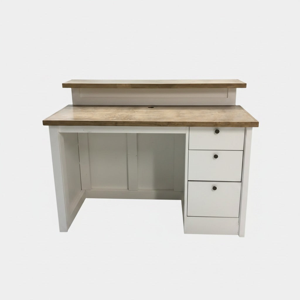 Employee-side view of a split-level reception desk with wide work surface, cable access, and three storage drawers. Handmade by Red Cloak Home