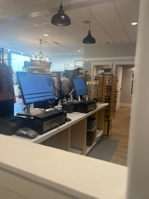 Rear view of a custom-built retail checkout counter with open back storage shelving and integrated tech wiring, built by Red Cloak Wood Designs