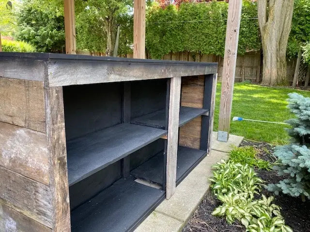 Backside of reclaimed wood bar with shelving, designed by Red Cloak Home for outdoor use