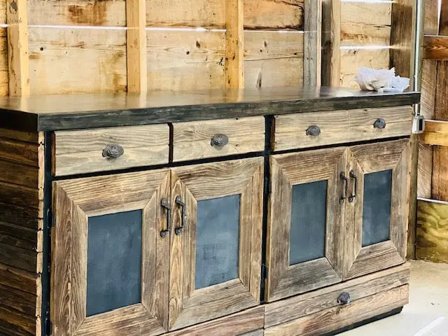 Close-up of barnwood back bar cabinet with black panel doors and four top drawers, handmade from 200-year-old hardwood.