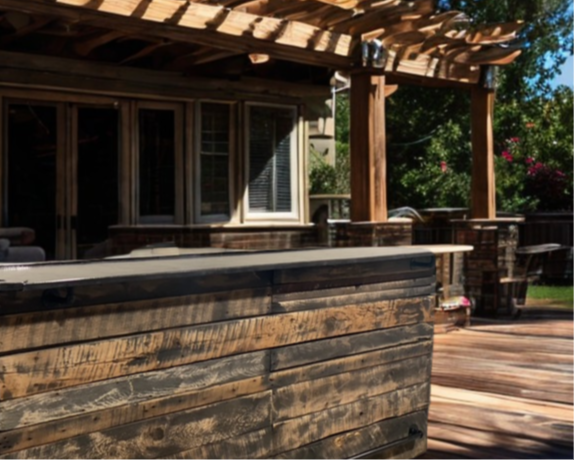 Handmade barnw ood bar installed beneath a backyard pergola, built for year-round outdoor entertaining by Red Cloak Home