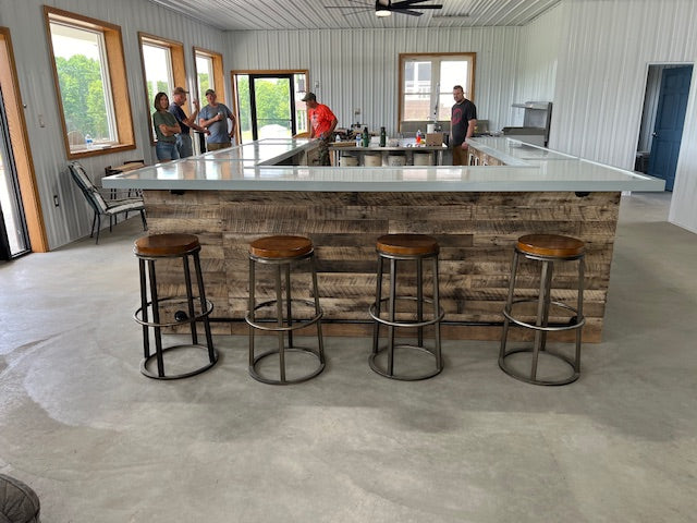 U-shaped wood bar with metal stools and white countertop installed in commercial space, part of the Big Daddy series by Red Cloak Home