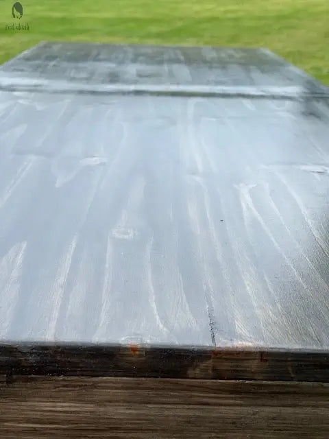 Smooth black wood bar top close-up with sealed finish for indoor or outdoor bar use, made from repurposed barn wood.