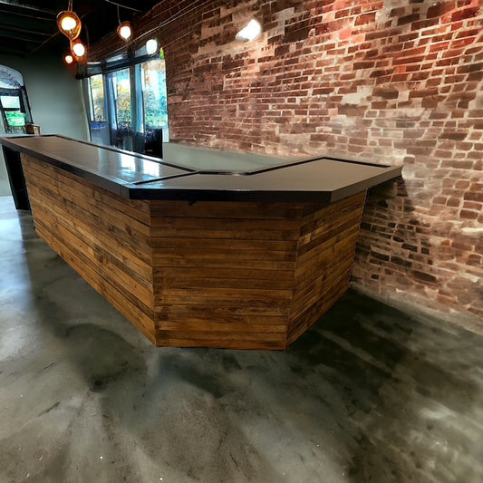 Custom diagonal corner bar by Red Cloak Wood Designs, indoor L shaped bar with black resin top and rustic wood paneling, perfect for home or business use