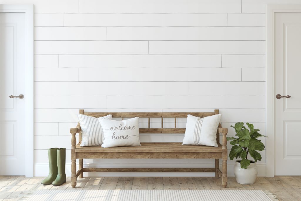Rustic wood bench with white pillows in a modern farmhouse entryway, Red Cloak Home custom furniture call-to-action banner.