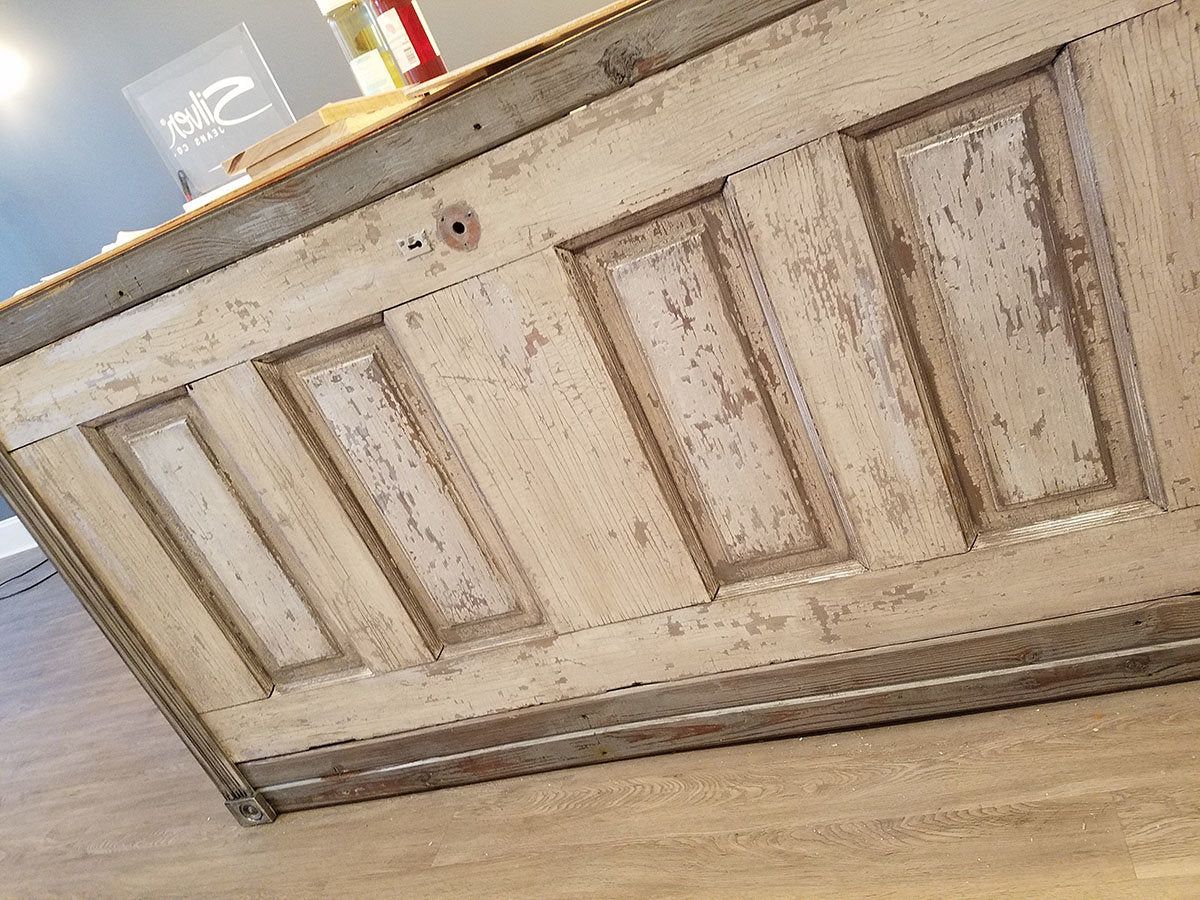 Close-up of distressed antique door panels used on a custom retail cash wrap counter. Handmade by Red cloak Home