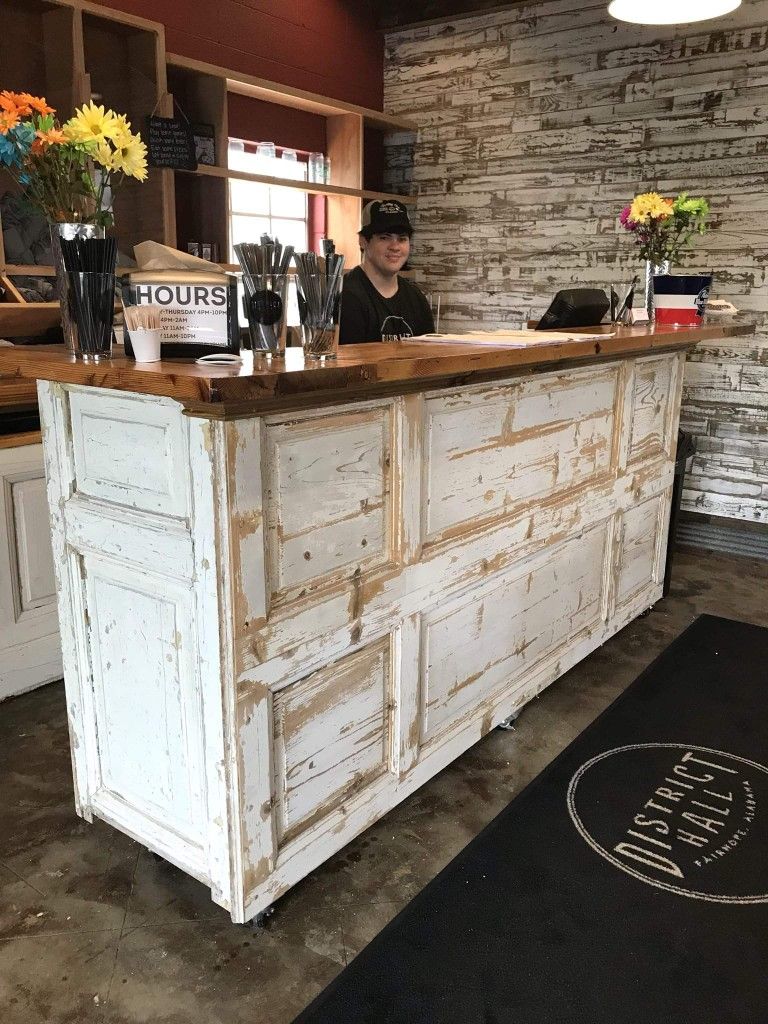 White distressed reclaimed door counter with wood top inside a restaurant or café. Handmade by Red Cloak Home