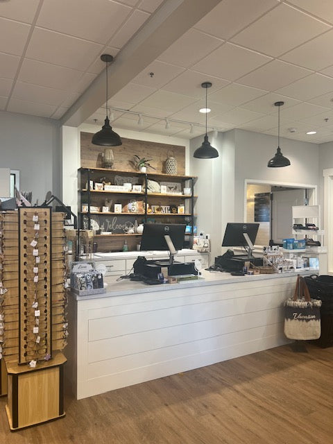 Full retail setup with pendant lights and custom shiplap front counter built by Red Cloak Wood Designs for boutique point of sale area