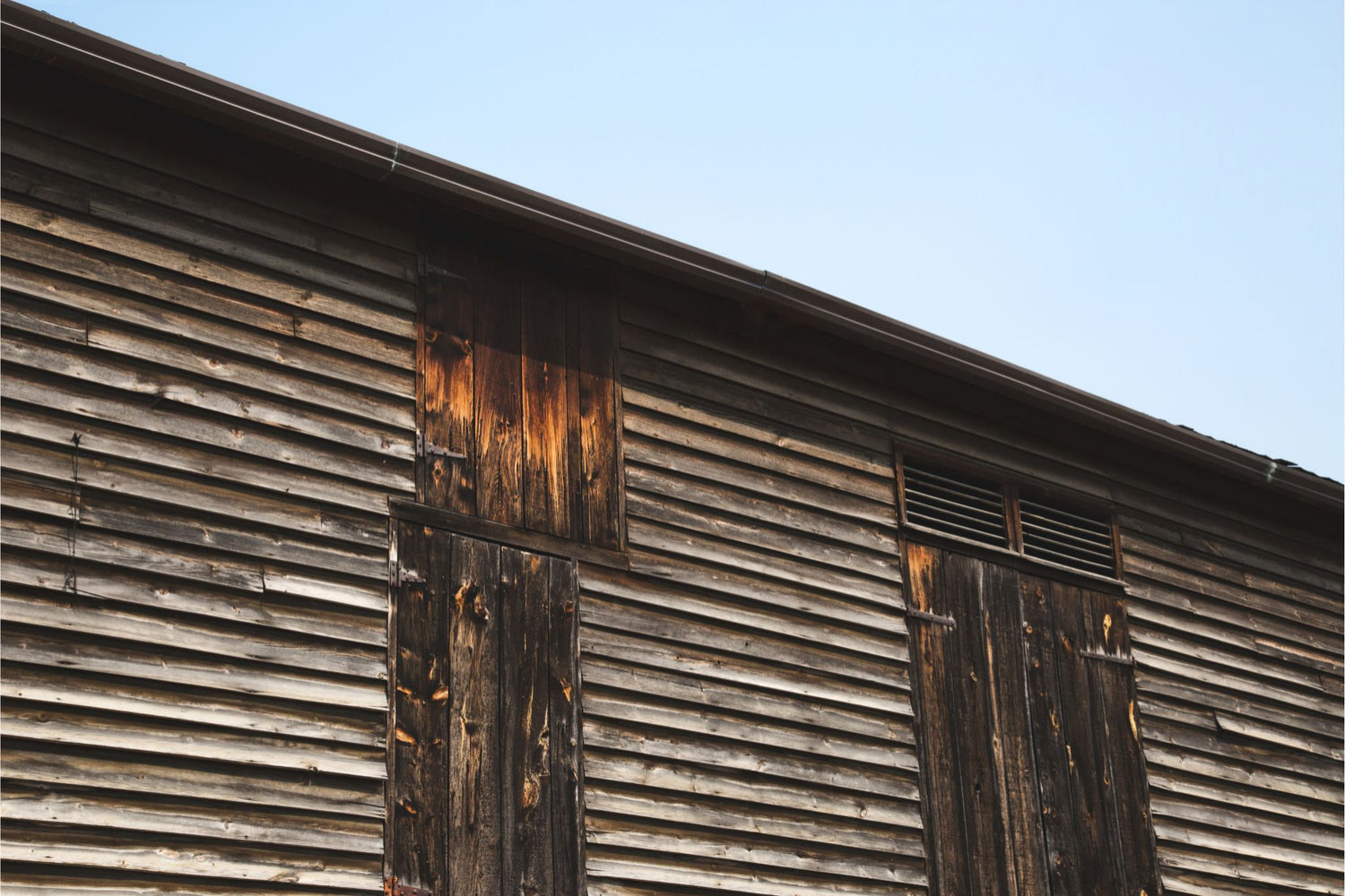 close-up of aged wooden barn siding with rich patina, the inspiration behind Red Cloak Home custom bar builds