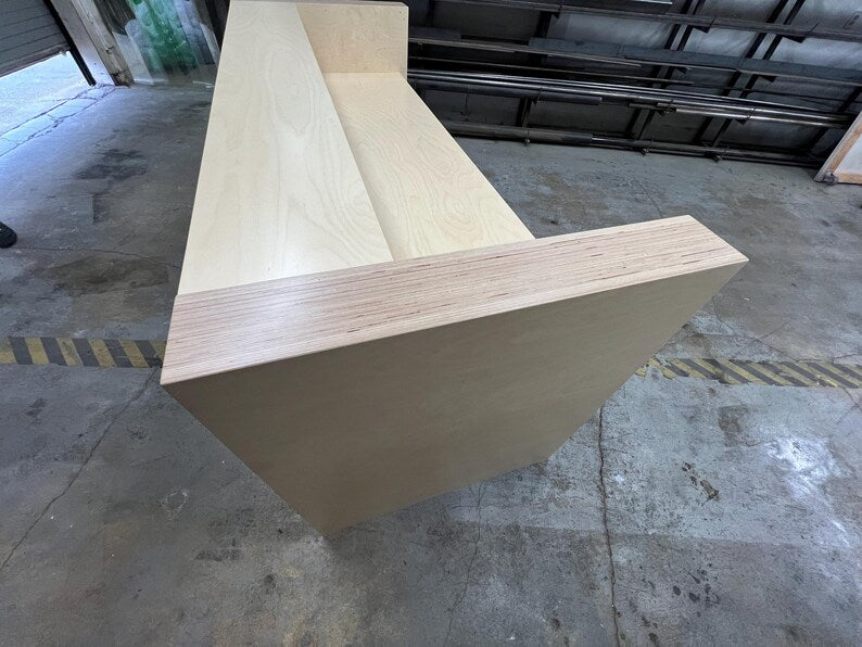 Employee-side view of a custom reception desk with open legroom, spacious desktop, and cable management. Handmade by Red Cloak Home