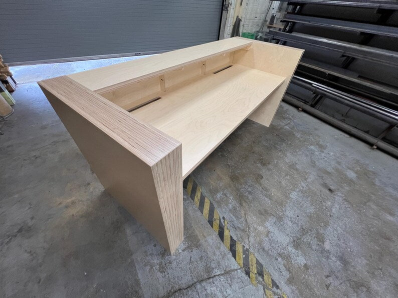 Rear corner view of a custom office reception desk showing the work surface and elevated front counter. Handmade by Red Cloak Home