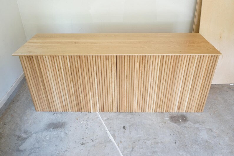 Straight front view of a modern fluted wood retail checkout counter with rounded corners. Handmade by Red Cloak Home