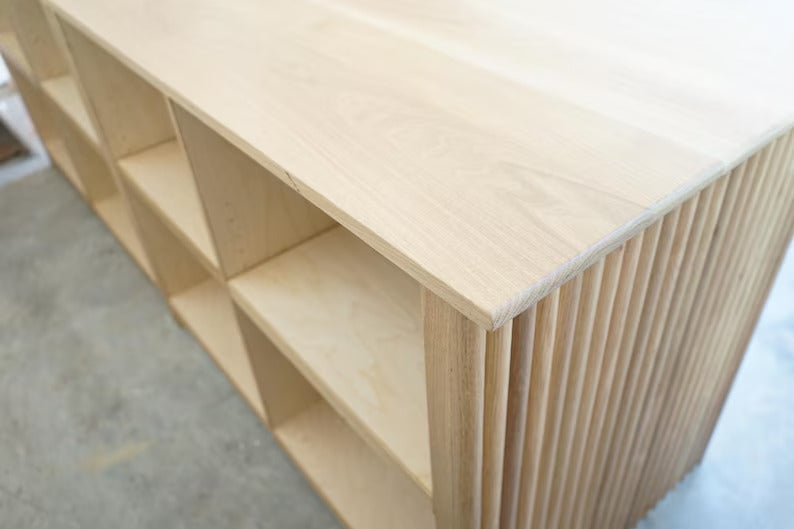 Close-up of open employee storage shelves and the fluted exterior on a custom cash wrap counter. Handmade by Red Cloak Home