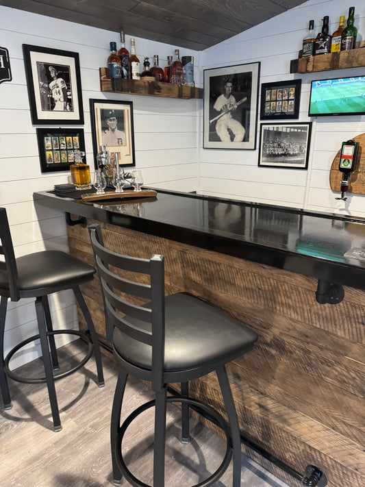 Reclaimed barnwood bar with black top in a sports-themed game room, handcrafted by Red Cloak Wood Designs