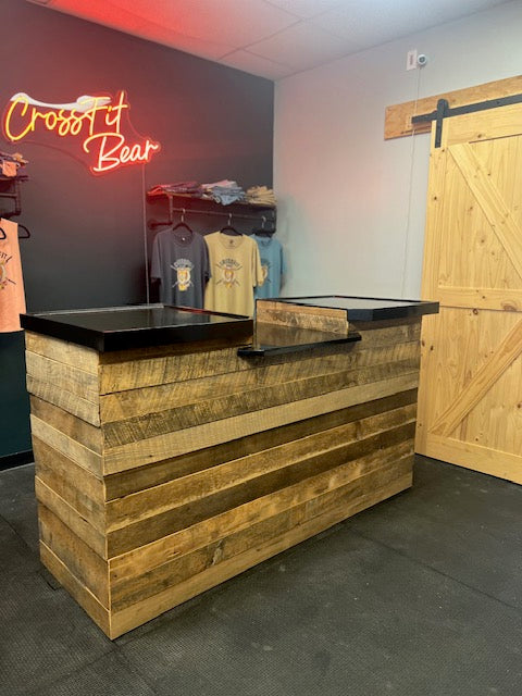 Wide view of custom barn wood POS counter with drop station and black top at CrossFit Bear retail setup