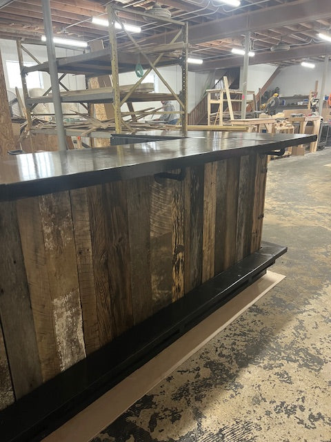 Back view of handmade wood Blackstone bar by Red Cloak Home, featuring metal footrail, reclaimed wood panels, and griddle-ready cutout.