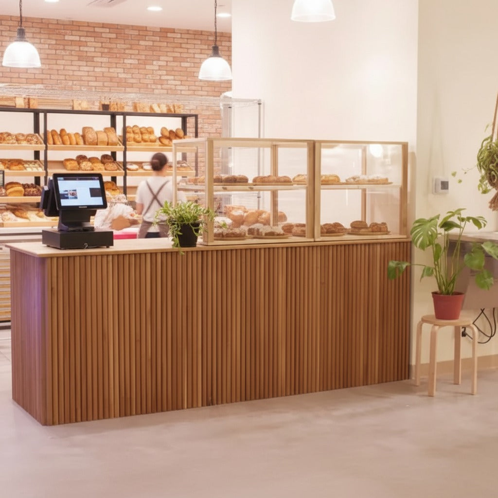 Custom bakery checkout counter with vertical wood slats, pastry display case, and POS register. Handmade by Red Cloak Home