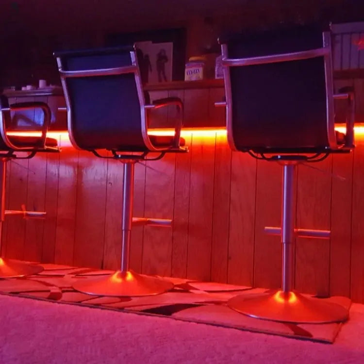 LED strip lighting glowing red under home bar counter with barstools, custom setup from Red Cloak Wood Designs
